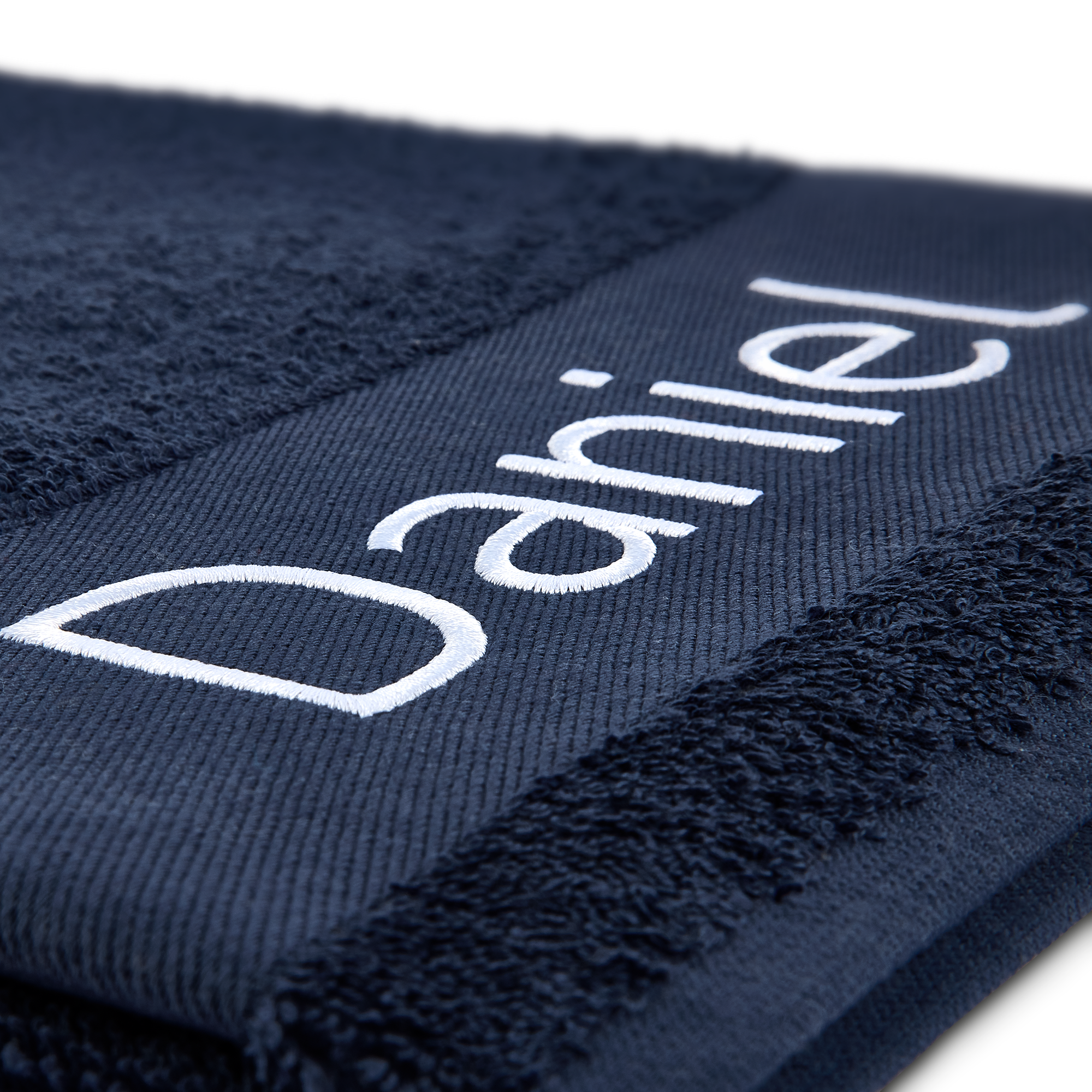 Toalha personalizada azul-marinho com o nome Daniel bordado em branco. Torna cada banho ainda mais especial com uma toalha personalizada.