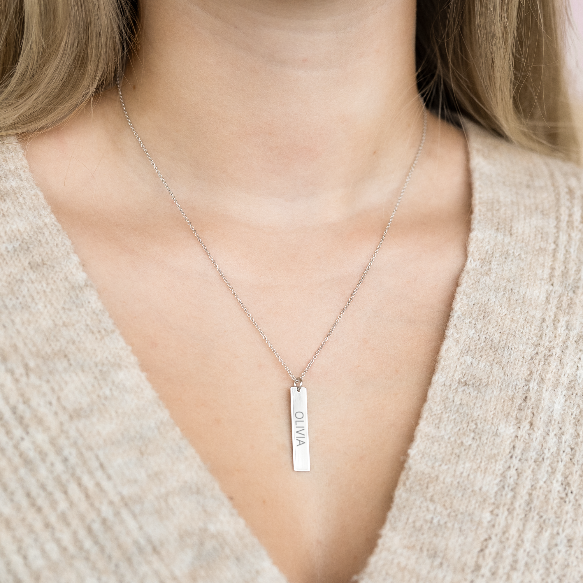 Silver initial necklace with a personalized engraved name OLIVIA on a bar pendant