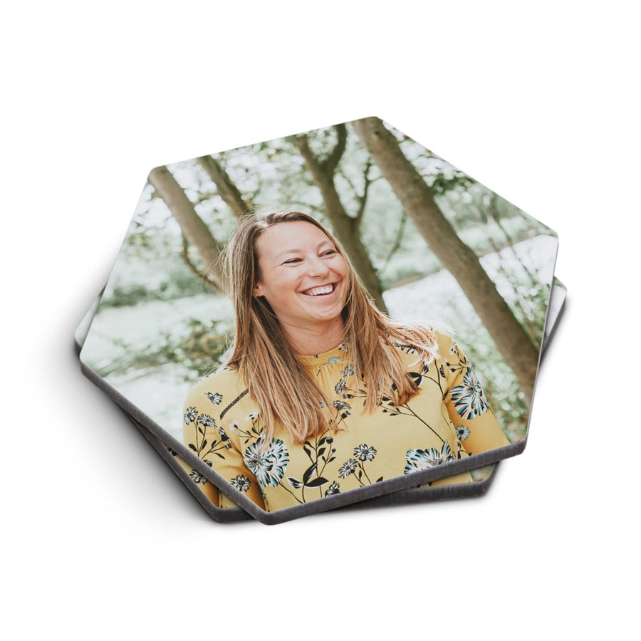 Sous-verres personnalisés avec la photo d'une femme souriante, imprimée sur deux sous-verres hexagonaux.