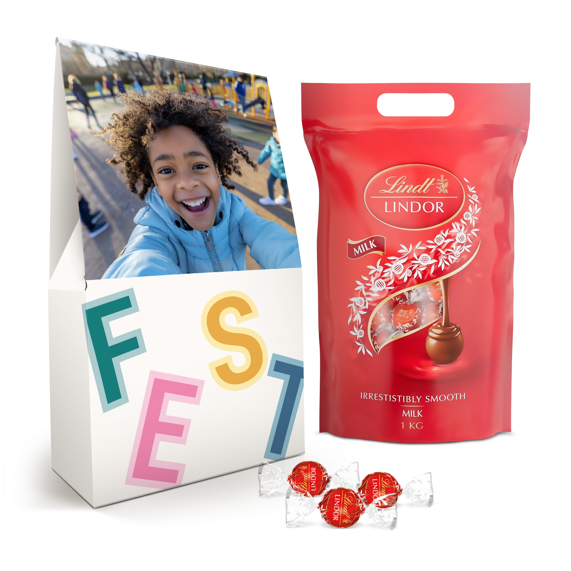 Geschenkbox mit einem lachenden Kind auf dem Deckel, beschriftet mit "FEST", und einem Kilo Lindt Lindor-Milchschokolade zum Überraschen.