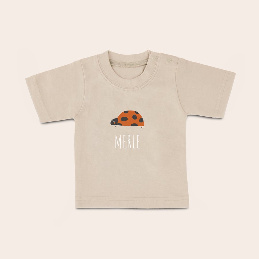 Baby shirt bedrukken Zandkleurig baby shirt met naam "MERLE" en lieve lieveheersbeestje opdruk, gepersonaliseerd met vrolijke foto.