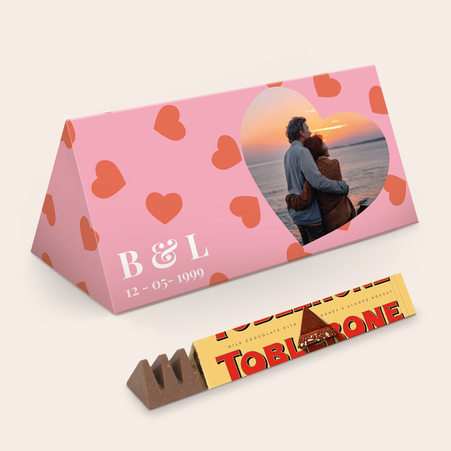 Personalizovaná Toblerone Personalizovaná čokoládová tyčinka XL Toblerone Selection s potištěnými jmény B&L, datem 12-05-1999 a fotografií páru v srdci.