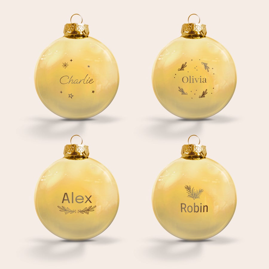 Glass bauble with name Four personalized glass Christmas baubles, each engraved with a different name and festive design to decorate your Christmas tree.
