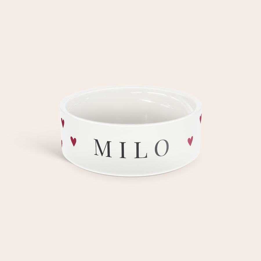 Henkilökohtainen lemmikkieläinten ruokakuppi Valkoinen keraaminen lemmikkiruokakulho, jossa on mustalla tekstillä painettu nimi Milo ja punaisia sydämiä. Tee ateriaajasta erikoista räätälöidyllä lemmikkiruokakulholla.