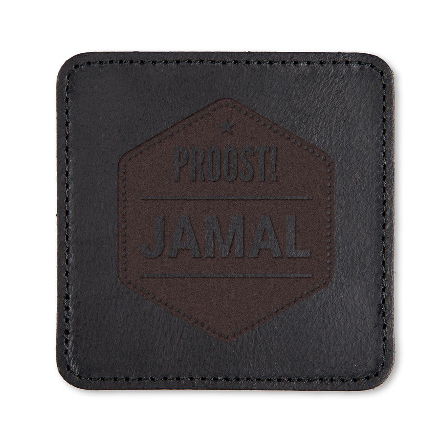 Zwarte leren onderzetter met ingegraveerd "Proost! Jamal" design, volledig te personaliseren.
