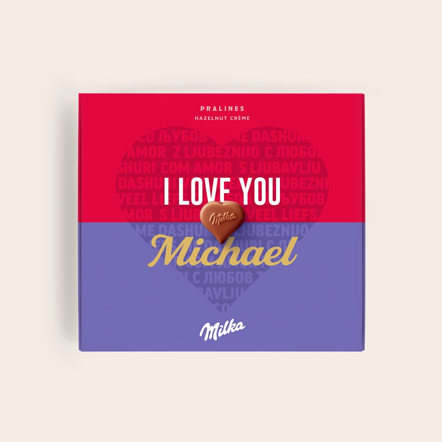 Milka Pralines - Love Roodpaarse Milka Say it with Milka chocolade giftbox met witte tekst "I LOVE YOU", gepersonaliseerd met de naam "Michael" in goudkleur en een hartvormige praline.