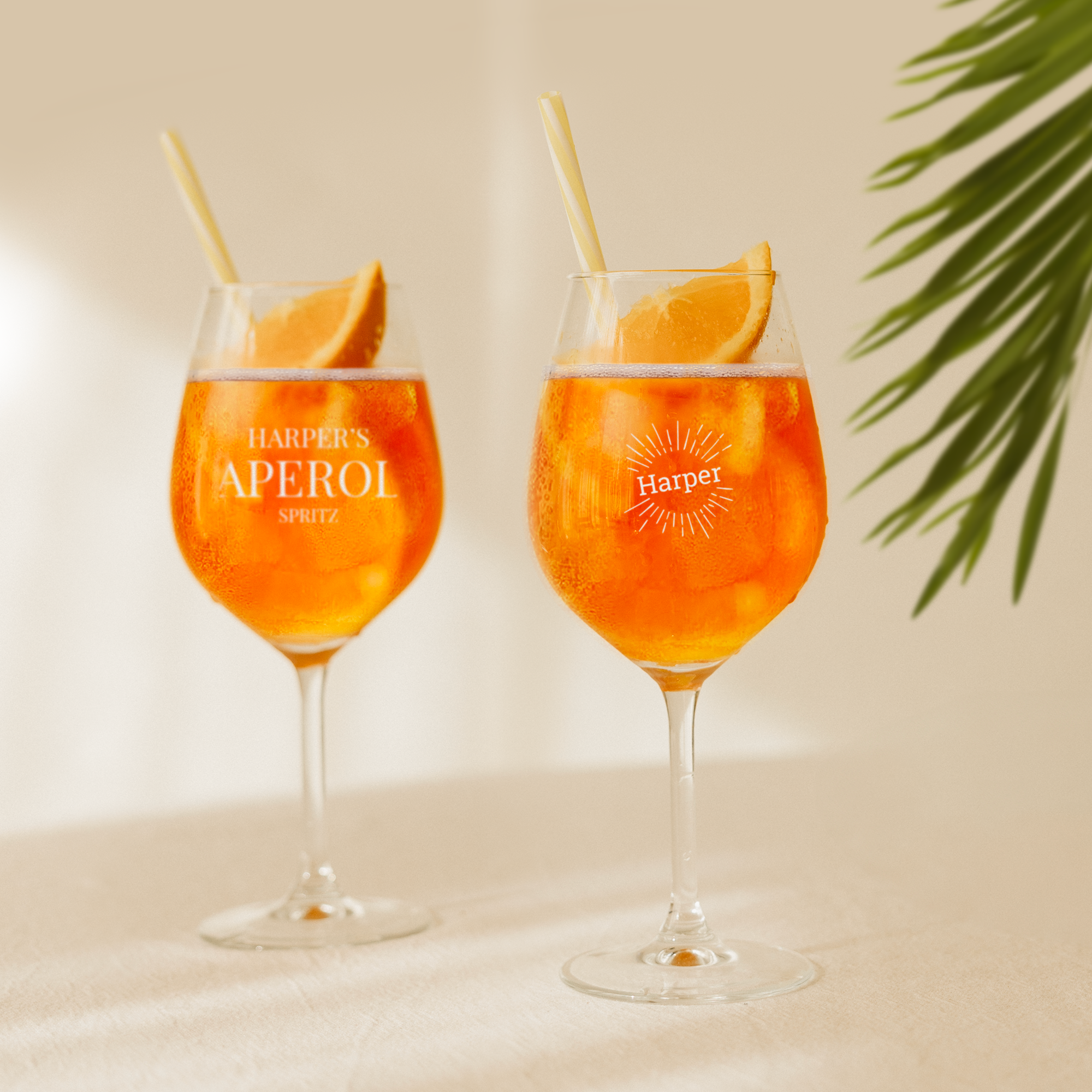 Dois copos personalizados de Aperol Spritz gravados com nomes, decorados com rodelas de laranja e palhinhas. Mime o seu amante de Aperol Spritz com o seu próprio copo personalizado.
