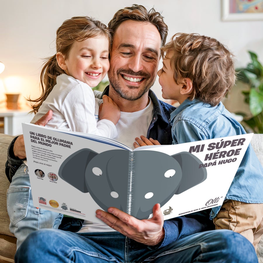 Libro personalizado XXL "El Mejor Papá del Mundo" - Ollimania Un padre sonriente leyendo un libro extra grande de Olli con sus dos hijos, personalizado con el nombre "Papá Hugo" y una foto impresa.