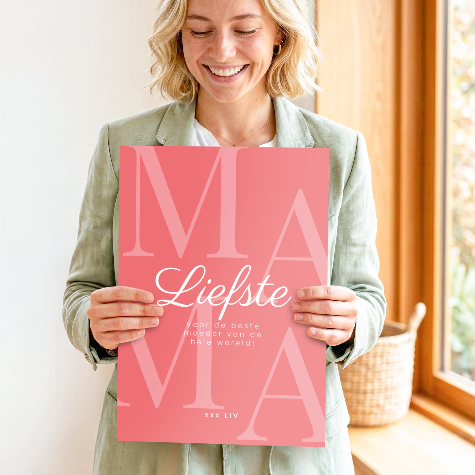 Vrolijke vrouw toont roze Mega Moederdag kaart personaliseren - 50 cm, met de tekst Liefste Mama en 'voor de beste moeder van de hele wereld' erop geprint, en een persoonlijke groet 'xxx Liv'.