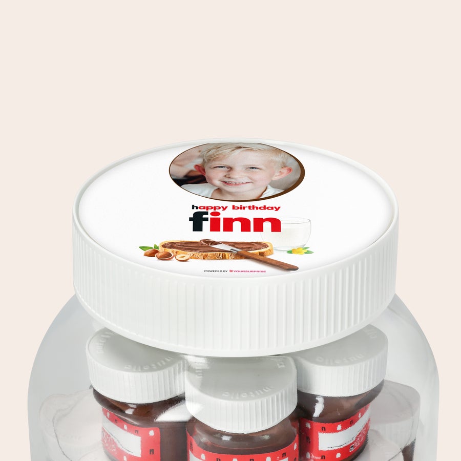Personalisiertes nutella® Glas XL mit Namen und Foto Personalisiertes nutella® Glas XL mit Namen und Foto. Die weiße Geschenkverpackung ist mit dem Foto eines lächelnden blonden Jungen, dem Text