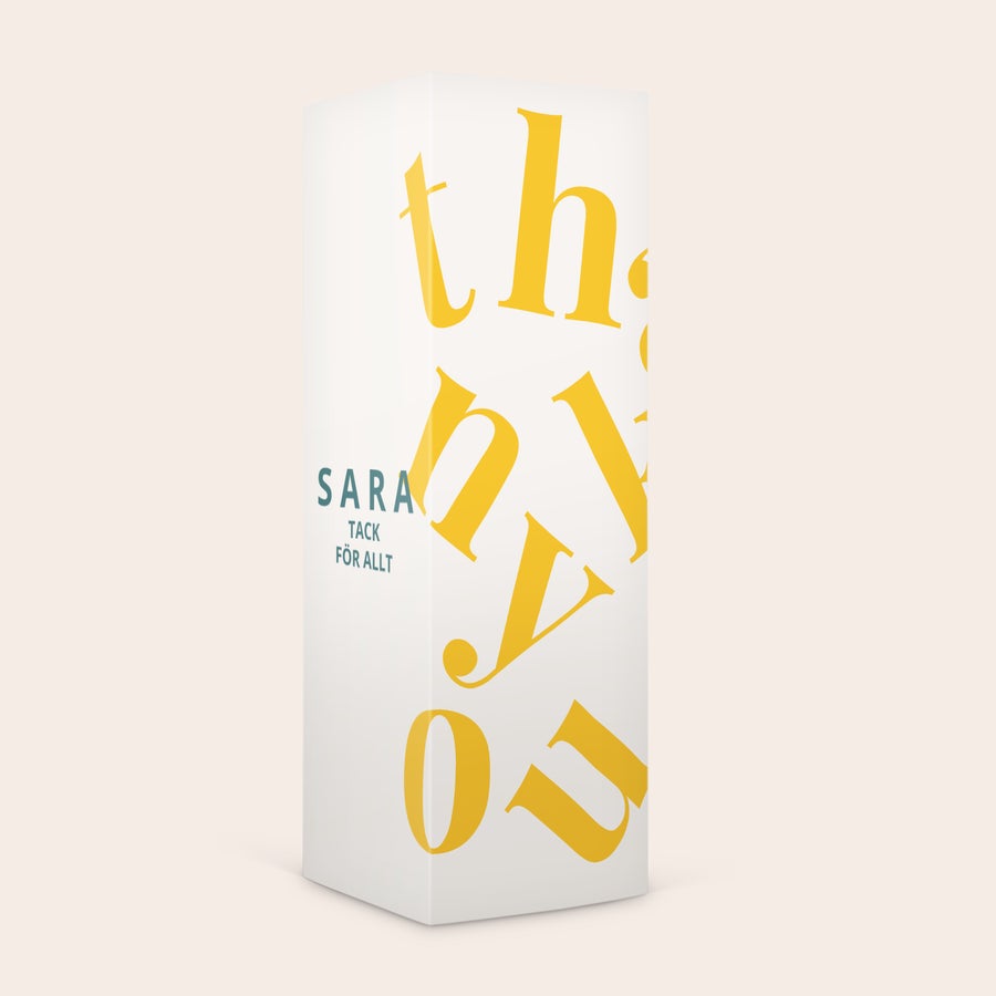 Personlig presentask - nötter En personlig presentask fylld med nötter. Askens vita design är tryckt med namnet Sara och texten tack för allt.