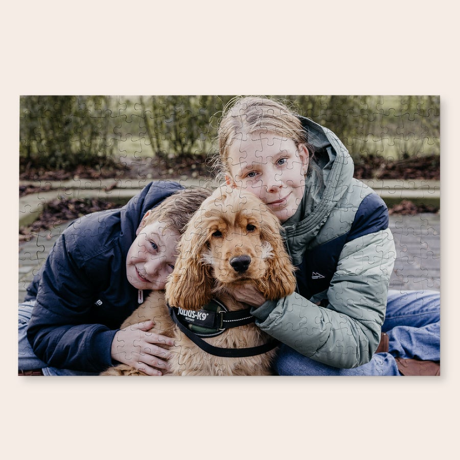 Stort puslespil med eget billede Puslespil med foto af to børn, der krammer en hund, med eget billede trykt på.