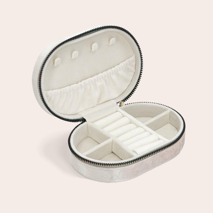 Personalised jewellery box Open personalised jewellery box - oval - beige, showing multiple compartments, ring rolls, and a pocket for custom engravings.