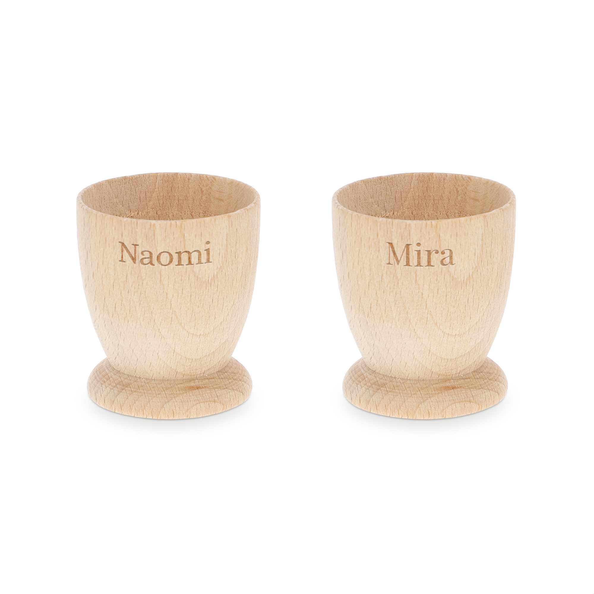 Twee gepersonaliseerde eierdopjes van beukenhout, gegraveerd met de namen Naomi en Mira, voor een onvergetelijk ontbijt