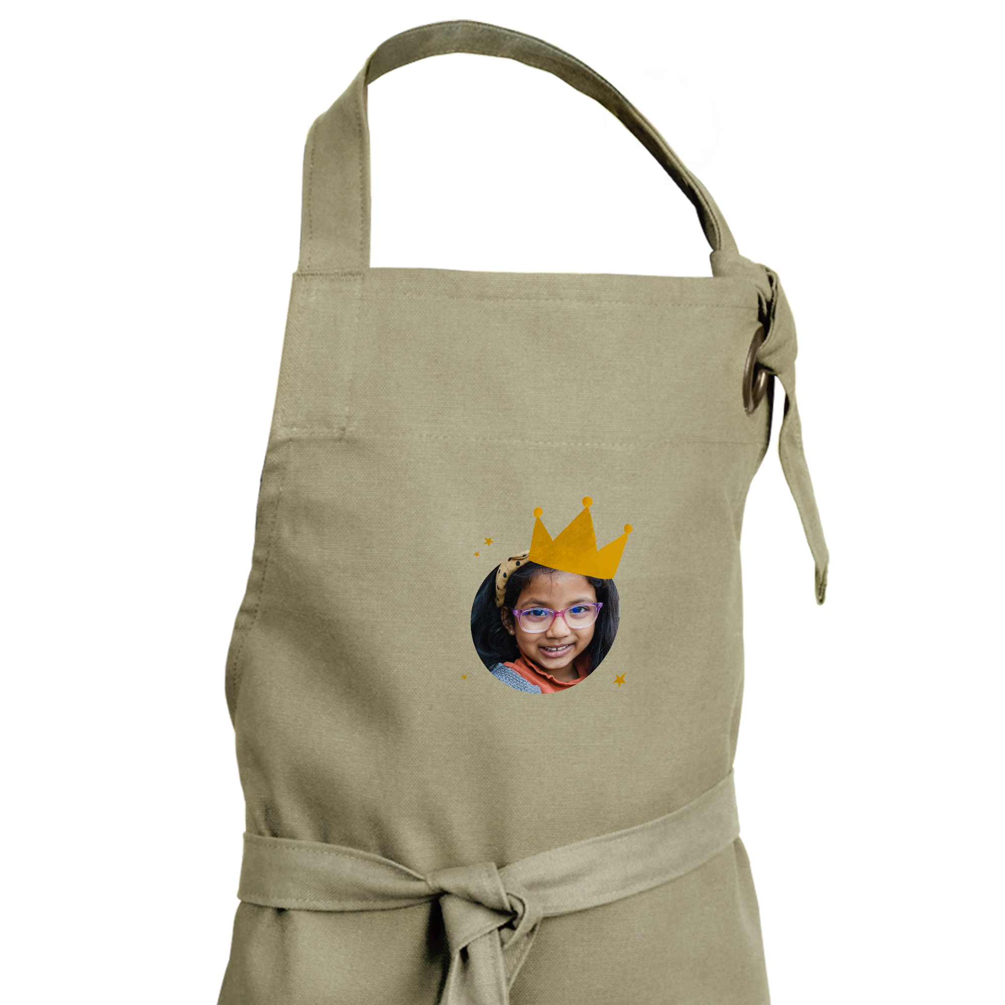 Delantal infantil beige personalizado con la foto de una niña sonriente, diseño de corona y estrellas.
