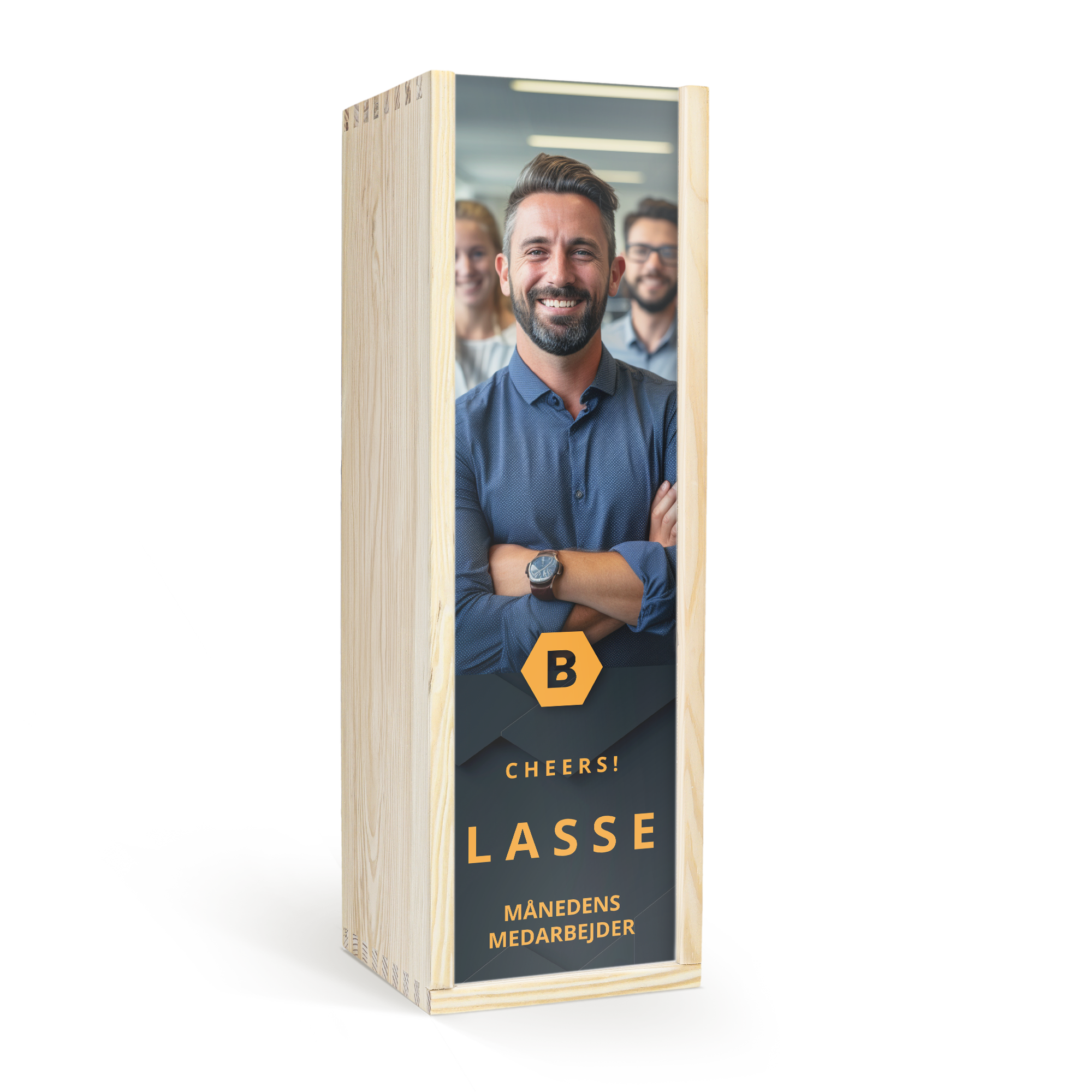 Gin i en trææske med printet billede af Lasse, teksten "Cheers! Månedens Medarbejder", og logo.