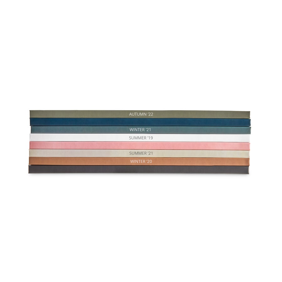 Personalised photo album - Photo only Stack of colorful personalized photo album spines with season and year printed on each