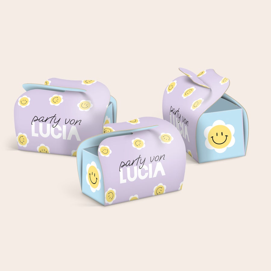 Personalisierte Mini-Toblerone-Mehrfachpackung als Geschenk Drei personalisierte Geschenkboxen für Schokolade, bedruckt mit einem Namen und lächelnden Blumen.