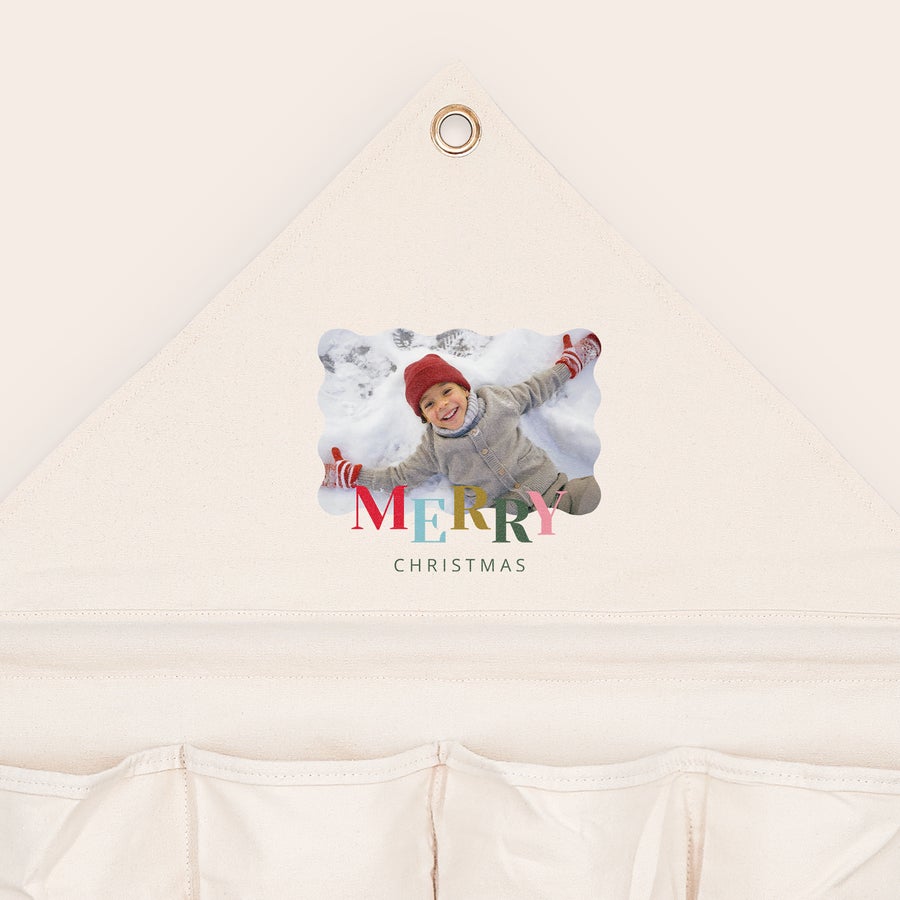 Kalendarz adwentowy z kieszonką z materiału Personalizowany materiałowy kalendarz adwentowy z wydrukowanym zdjęciem dziecka leżącego na śniegu i tekstem Merry Christmas