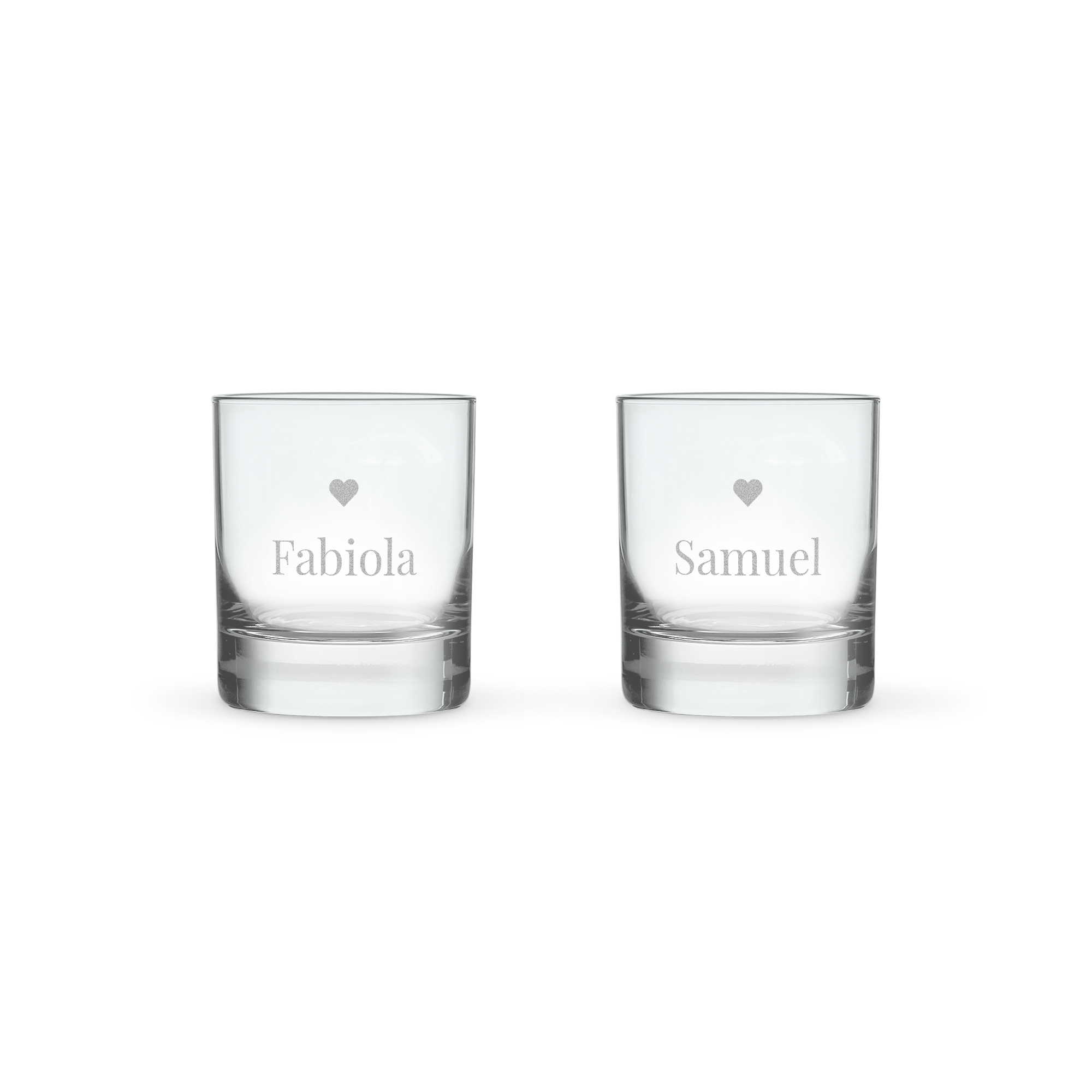 Dos vasos de whisky personalizados con un corazón, uno grabado con "Fabiola" y otro con "Samuel".