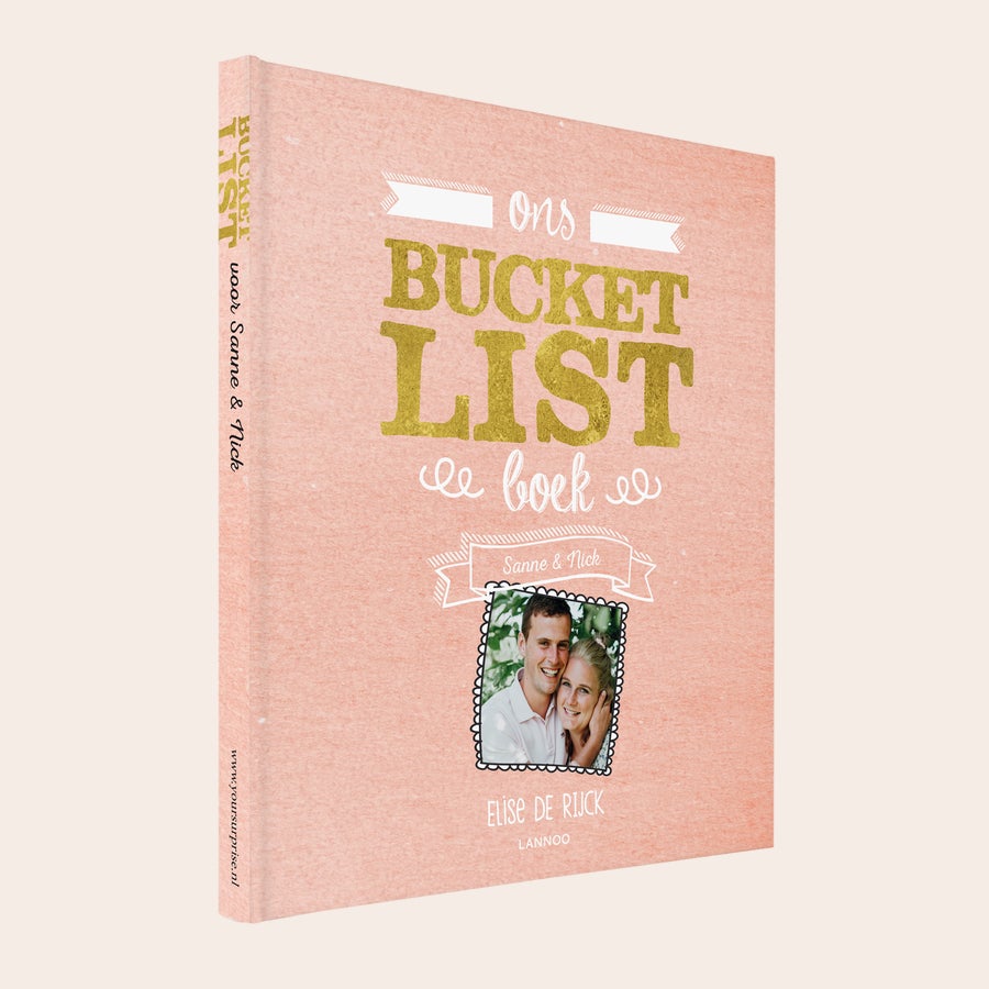 Het Bucketlist boek voor koppels Roze bucketlist boek voor koppels, bedrukt met goudkleurige letters "Ons Bucketlist Boek", namen "Sanne & Nick" en een persoonlijke foto.