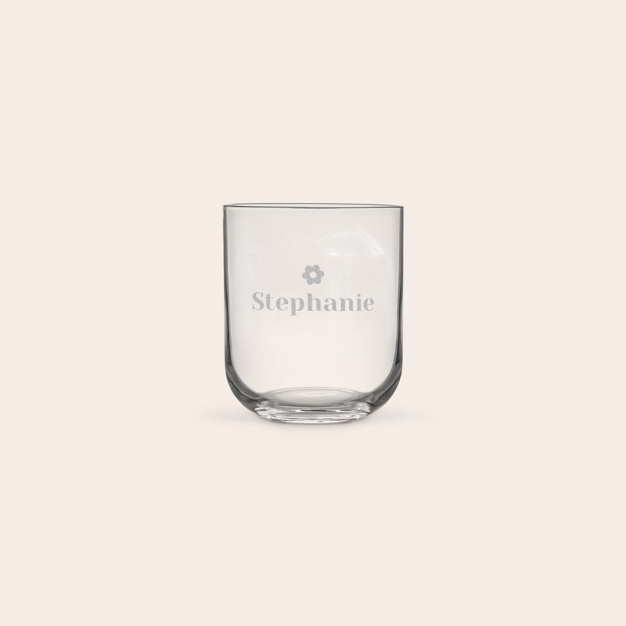 Personalised water glass A luxurious personalized water glass with the name Stephanie and a flower icon engraved on the side.