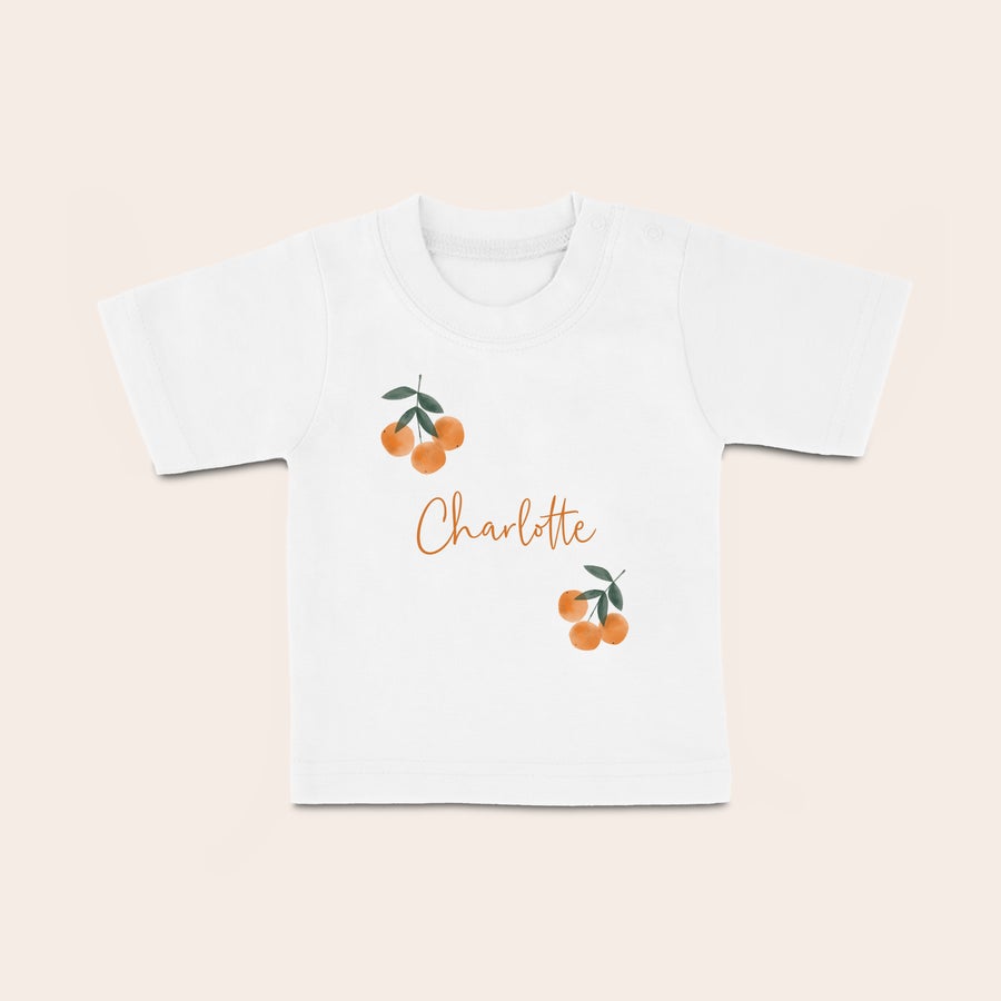 Baby shirt bedrukken Wit baby shirt met naam Charlotte, oranje fruitprint en korte mouwen, bedrukt met eigen tekst