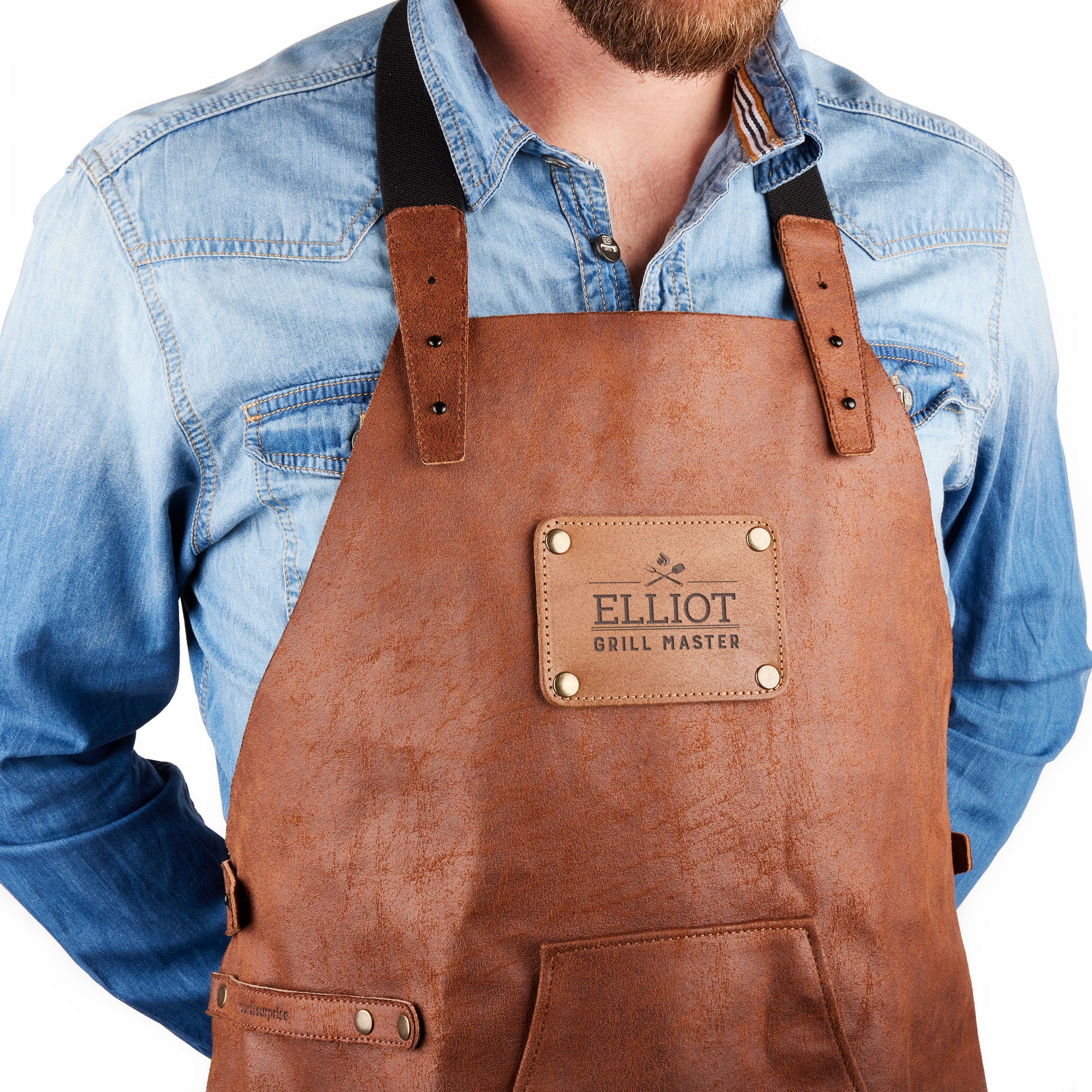 Kierrätetystä nahasta valmistettu essu, jossa nimikyltissä kaiverrettu nimi "ELLIOT GRILL MASTER" ja kuvio.