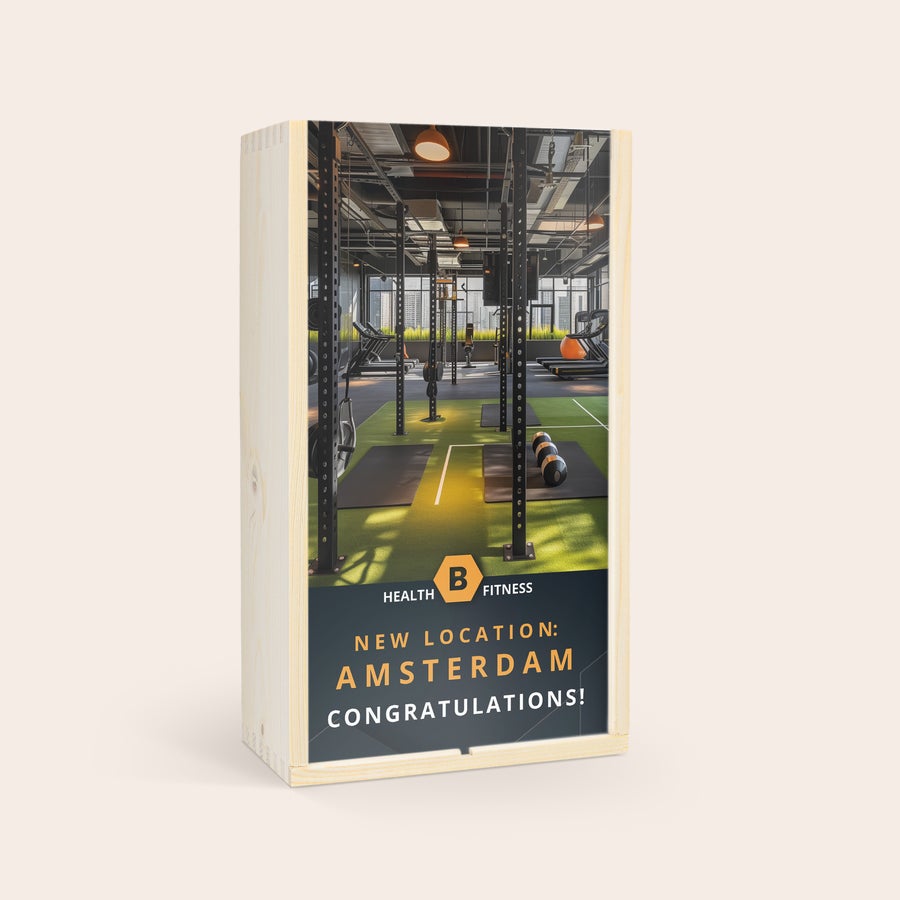 Öl gåva uppsättning - Westmalle Dubbel och Tripel Westmalle Dubbel och Trippel i trälåda med tryckt foto av ett gym och texten NEW LOCATION AMSTERDAM CONGRATULATIONS