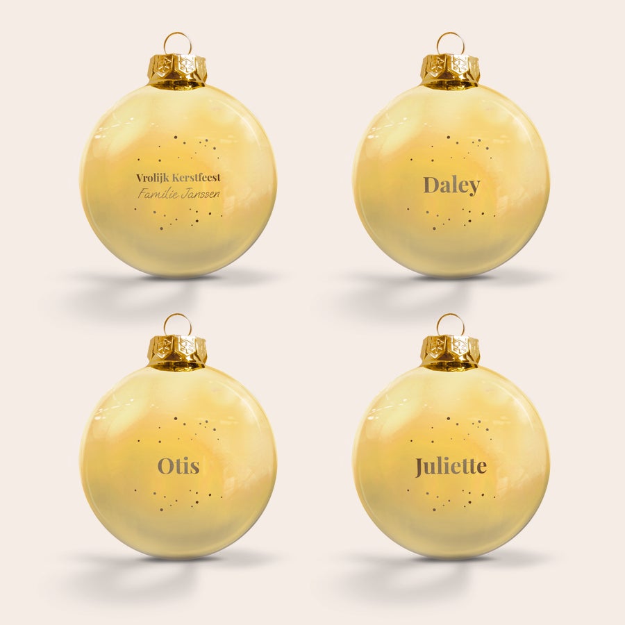 Kerstbal met naam Vier gepersonaliseerde gouden glazen kerstballen gegraveerd met namen als 'Otis', 'Juliette', 'Daley' en 'Familie Janssen'.