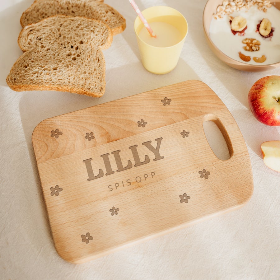 Treplate til brød Et gravert trebrett med navnet LILLY og teksten SPIS OPP, omkranset av blomsterdesign.