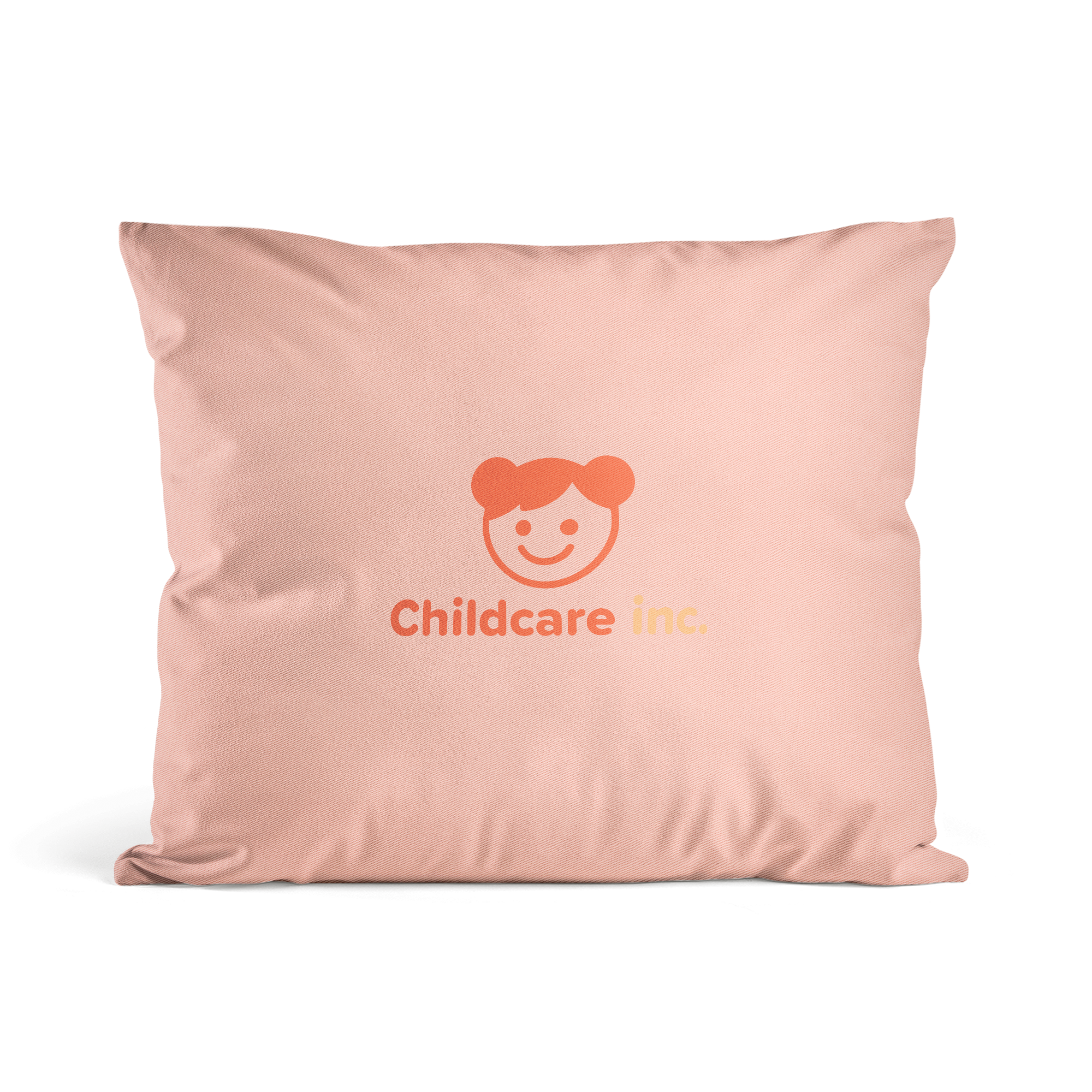 Rosa pute med trykt "Childcare inc." og et barneansikt, en original pute med personlig bilde.