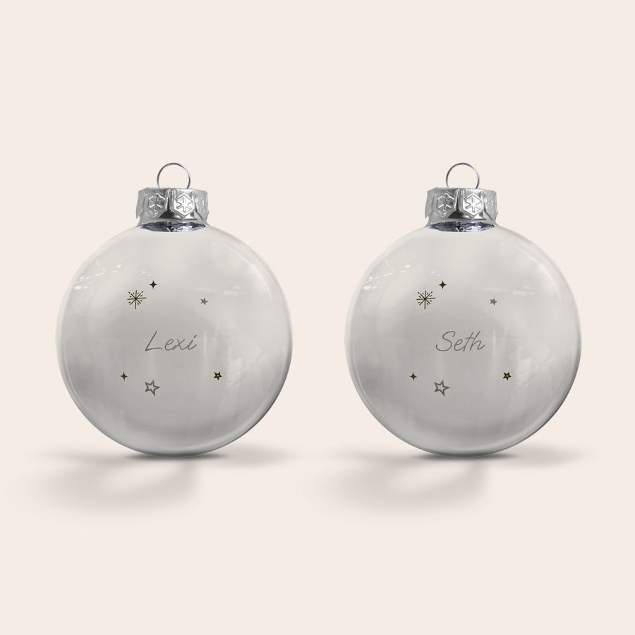 Boule de Noël Personnalisée en Verre Boules de Noël en verre personnalisées gravées avec les noms Lexi et Seth entourés détoiles et dun flocon