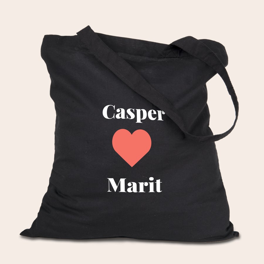 Tote bag bedrukken Zwarte gepersonaliseerde stoffen totebag bedrukt met de namen Casper en Marit en een rood hart.