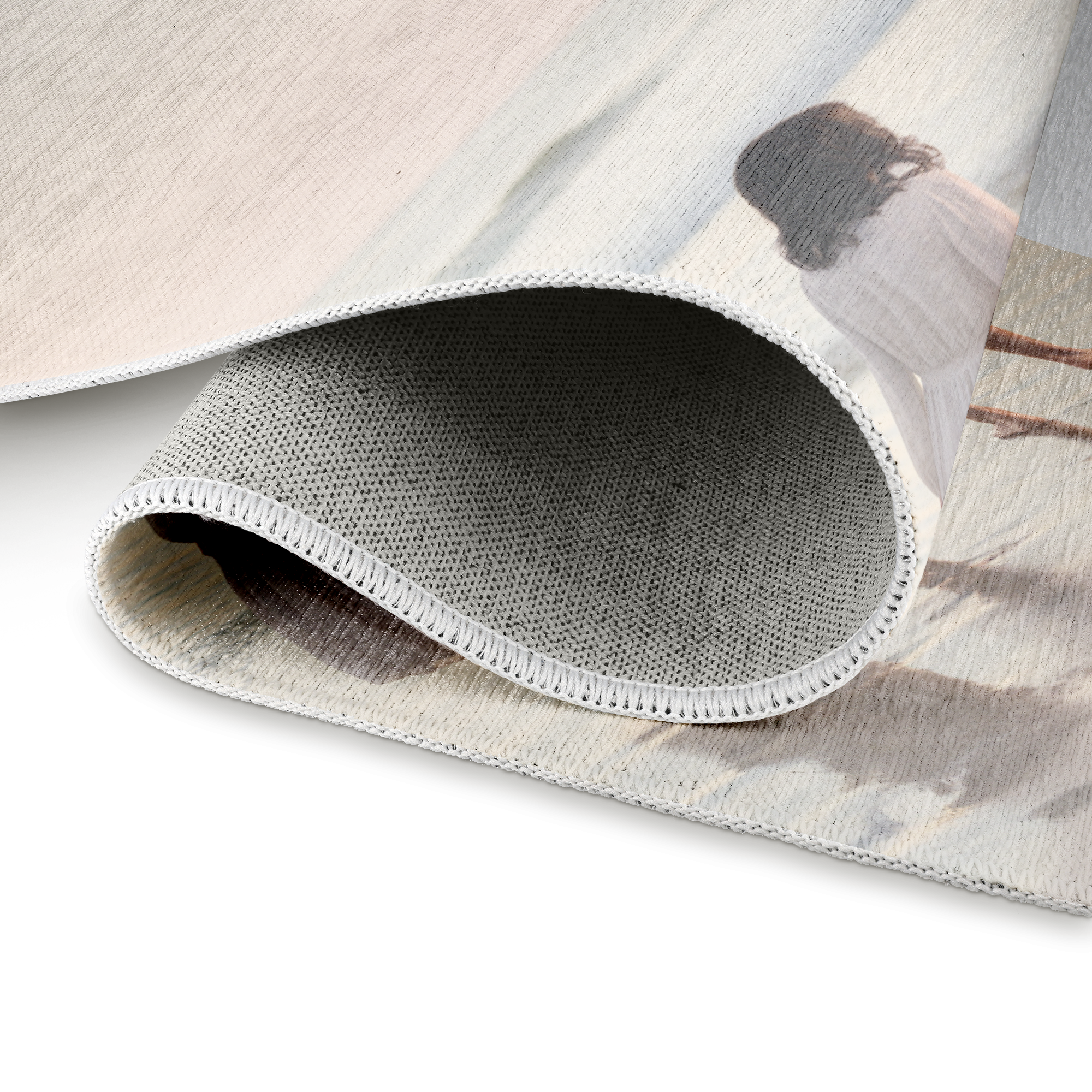 A personalized rug with a subtle printed photo, rolled to show the non-slip backing and white stitched edge.