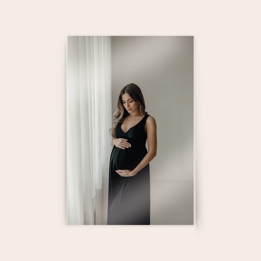 Foto su acrillico Una foto in acrilico mostra una donna incinta in abito nero, stampata su una piastra in acrilico personalizzabile con la tua foto