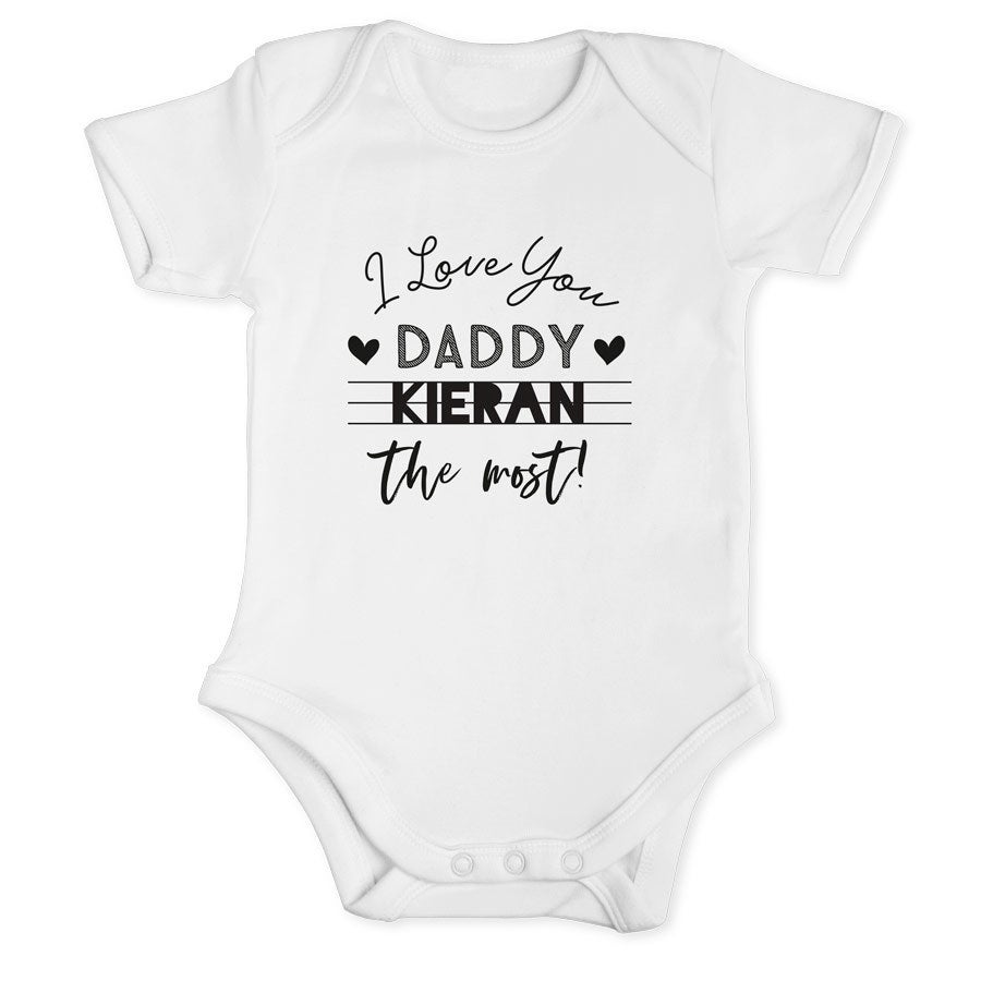 Hvit babybody med I Love You Daddy Kieran the most trykt tekst, en fin gave til pappas første farsdag.