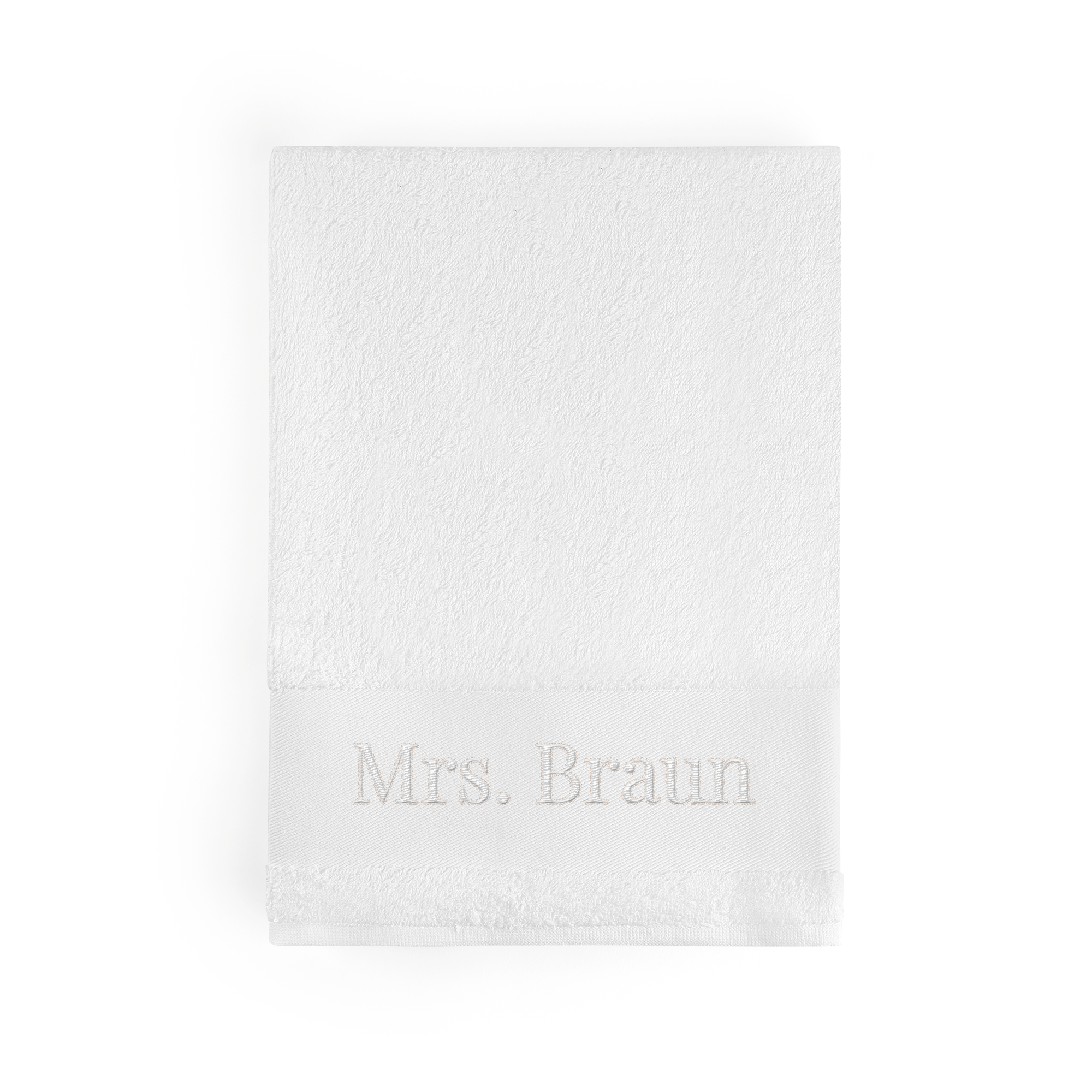 Weißes personalisiertes Badetuch, bestickt mit dem Namen "Mrs. Braun" in dezenter Farbe, schafft etwas Besonderes.