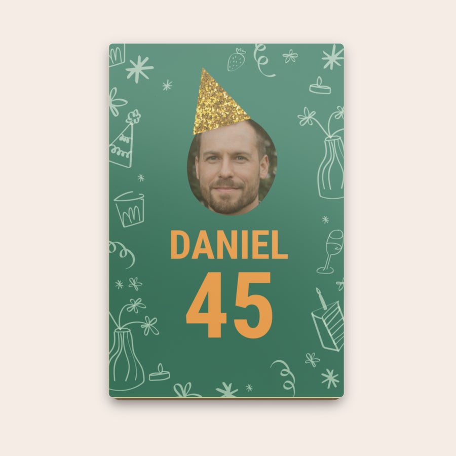 Chokladbrev Personligt chokladbrev med ett foto av Daniel med festhatt och texten Daniel 45, tryckt på chokladens yta.
