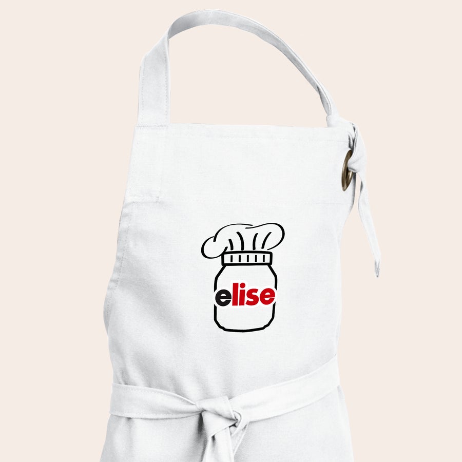 nutella®-Geschenkset - Backspaß Weiße personalisierte Kochschürze mit aufgedruckter Nutella-Glas-Grafik, darüber eine Kochmütze und dem Namen Elise