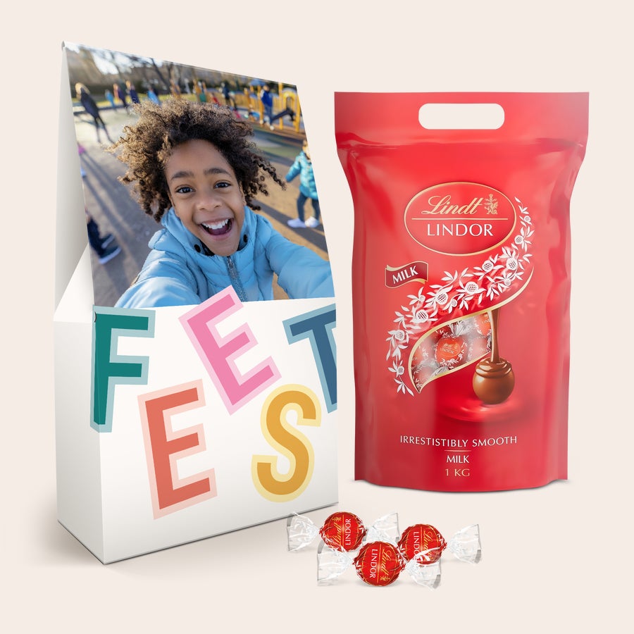 Grote Lindt box personaliseren Witte giftbox met foto en tekst “FEEST”, met daarnaast een zak van 1 kilo Lindor melkchocoladebonbons.