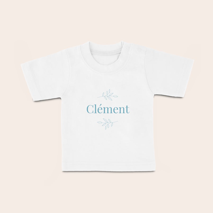 T shirt bébé personnalisé T-shirt bébé blanc personnalisé avec le prénom Clément imprimé en bleu et des motifs de feuilles. Votre petit bout de chou sera super stylé avec ce t-shirt joyeux personnalisé avec photo ou nom.