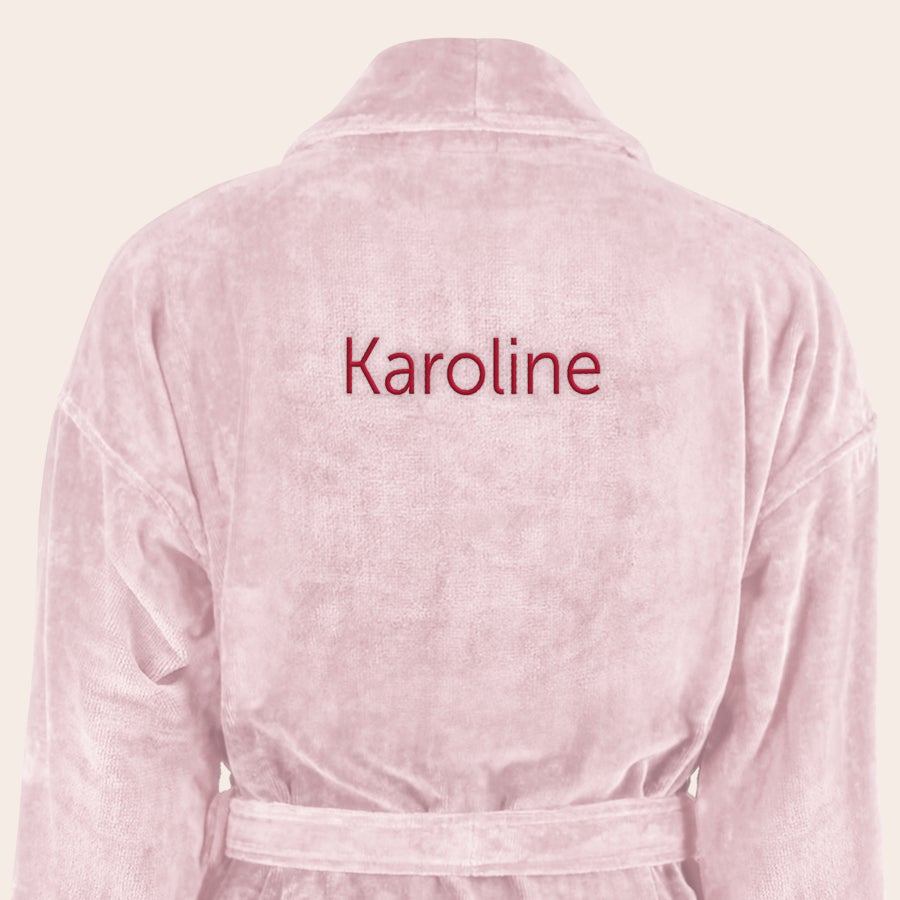 Badekåpe for kvinner med navn Luksuriøs personlig badekåpe i rosa, brodert med navnet Karoline i rød tråd på ryggen.