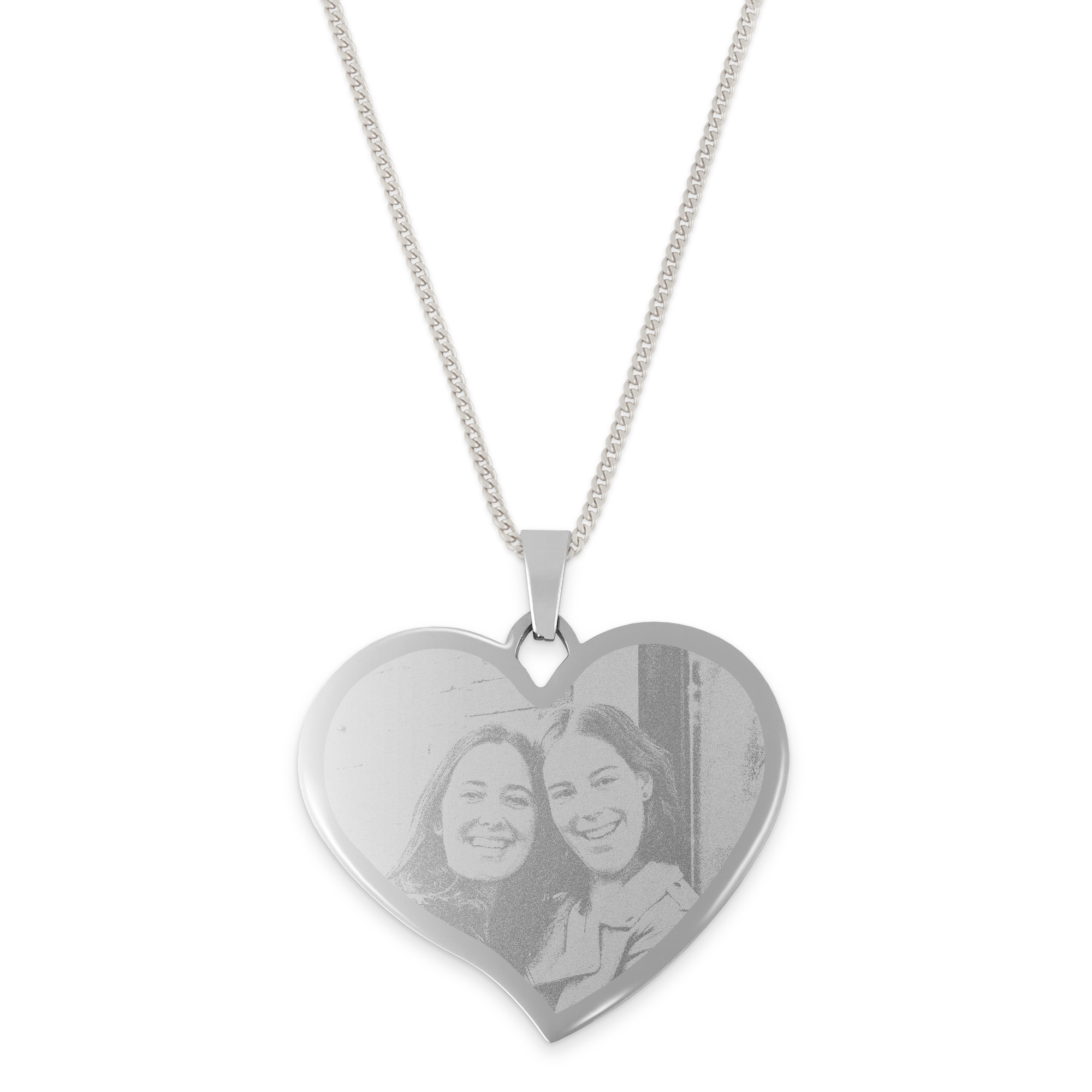 Silver heart shaped pendant engraved with a photo of two smiling women, attached to a delicate chain.