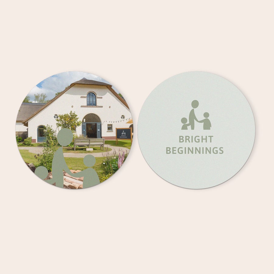 Personlige veggpaneler Runde forex fotofliser til å pynt veggen din, en med bilde av et hus og den andre med "Bright Beginnings" tekst og ikon, begge med eget design.