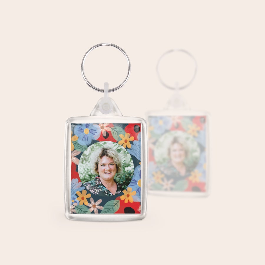 Sleutelhanger met logo Unieke set sleutelhangers bedrukt met een foto van een vrouw en bloemmotief, dubbelzijdig personaliseerbaar.