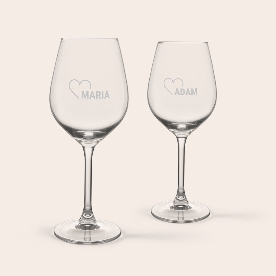 Wijn borrelpakket personaliseren Twee gepersonaliseerde wijnglazen met de namen Maria en Adam en een hartje, gegraveerd voor feestelijk borrelen.