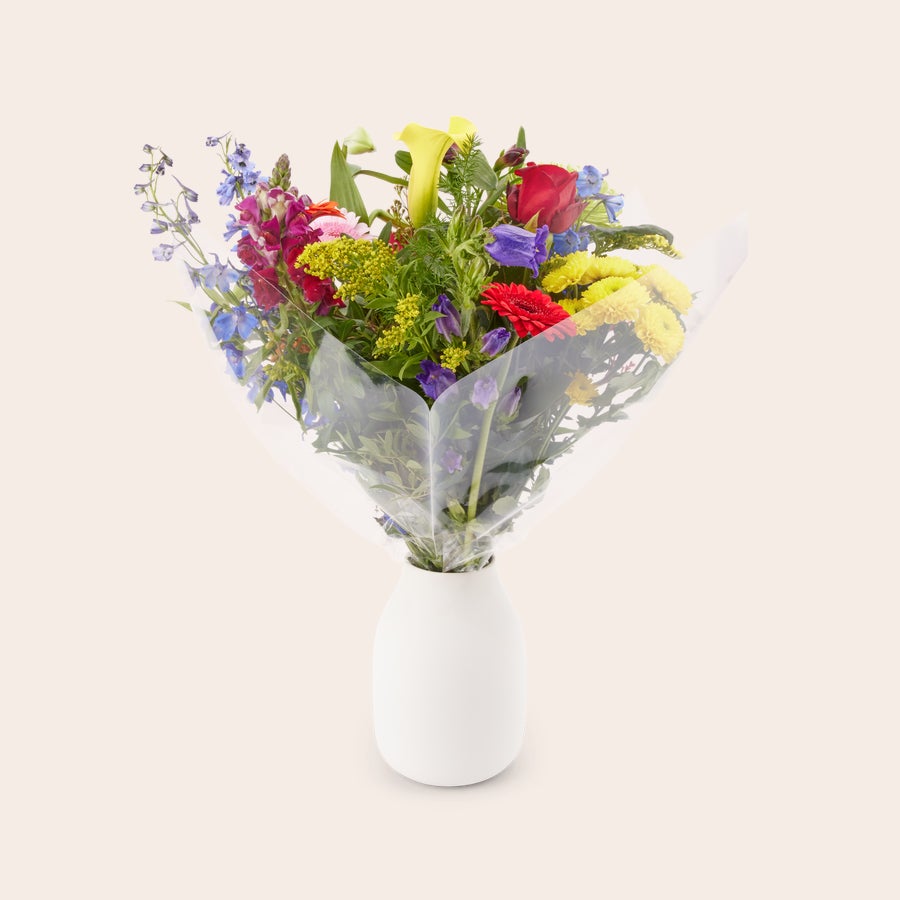 Blumen - Pflückblumen Bunt Farbenfroher Strauß Pflückblumen mit roten, gelben und blauen Blüten in einer transparenten Folie, bereit zum liefern mit kostenloser Geschenkkarte.