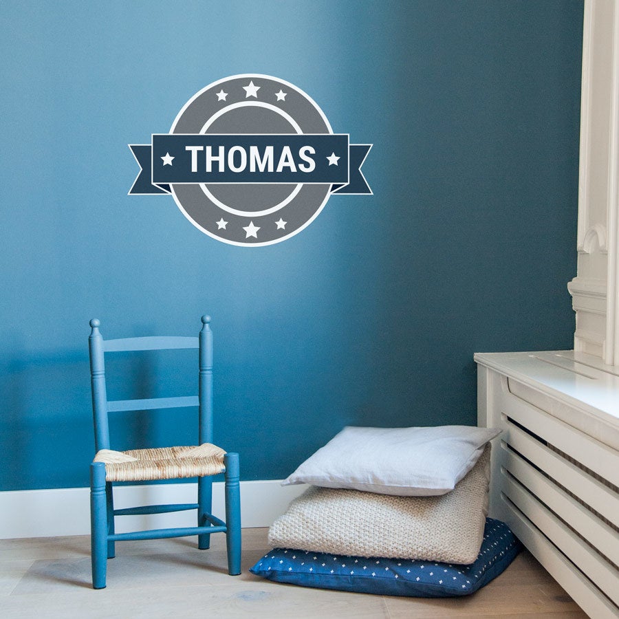 Väggdekal med tryckt namn Thomas i en rund grå och vit design för barnens sovrum