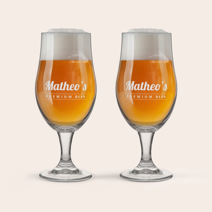 Calice da Birra Personalizzato Due bicchieri da birra a calice con incisione personalizzata "Matheo's Premium Beer" pieni di birra dorata e schiuma, perfetti per sorprendere un amante della birra con un bicchiere con nome o testo inciso